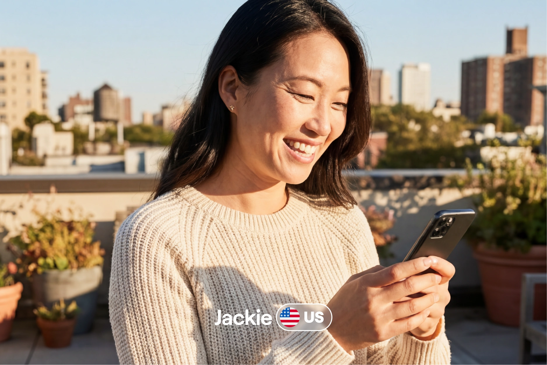 Jackie from the US smiling at her phone on a rooftop